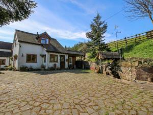a house with a stone driveway in front of it at White Cottage in Hopton Wafers