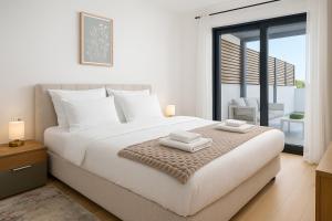 a bedroom with a large bed with two towels on it at Luxury Apartment Mona with Garden & Jacuzzi in Zadar, Borik in Zadar