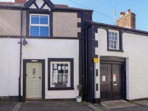 a white and black house with two doors at Derwen House in Llangollen