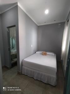 una piccola camera da letto con un letto e un lavandino di Casa Pirenópolis a Pirenópolis Altre 11 foto