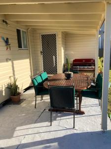a wooden table and chairs on a patio at 9 Ash Street Cessnock in Cessnock