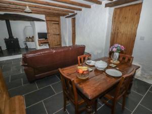 a living room with a table and a leather couch at Panteurig Cottage in Goodwick