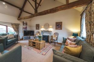 een woonkamer met banken en een open haard bij Beaver Cottage in Thirsk