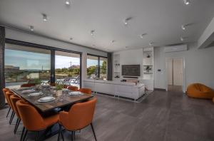 a dining room with a table and chairs and a couch at Villa One Debeljak Zadar in Debeljak