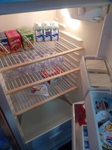 an open refrigerator filled with food and milk at LaCiliegia monolocale in Bonnanaro