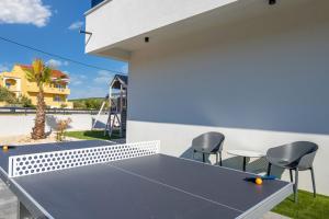 a ping pong table in the backyard of a house at Villa One Debeljak Zadar in Debeljak
