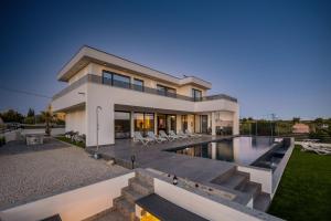 a house with a swimming pool in front of it at Villa One Debeljak Zadar in Debeljak