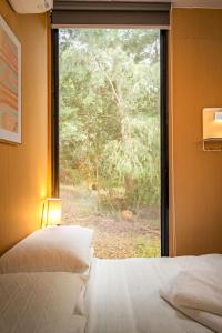 a bedroom with a window looking out at a forest at Forest Nook Tiny House by Tiny Away in Buffalo