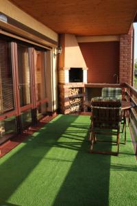 a patio with a table and chairs on a green floor at Два дома на берегу Лимана in Vapnyarka