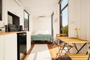 a kitchen and living room with a bed and a table at Gem near the Dam by Tiny Away in Romsey