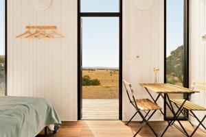 ein Schlafzimmer mit einem Bett und einem Tisch und Stühlen in der Unterkunft Gem on the Hill by Tiny Away in Romsey