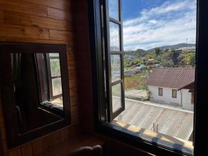 an open window with a view of a house at Homestay Nhà Mộc in Da Lat