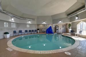 a large swimming pool in a large room with blue chairs at Holiday Inn Express & Suites Oklahoma City Northwest by IHG in Oklahoma City
