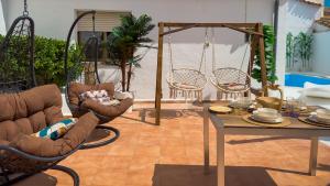 a living room with chairs and a table and swings at Casa Rural Oasis in Zulema +13 photos