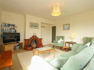 a living room with a couch and a fire place at Tegawelon in Harlech