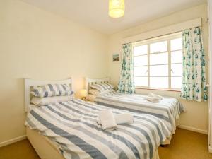 two beds in a room with a window at Tegawelon in Harlech