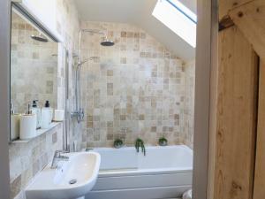 ein Badezimmer mit einer weißen Badewanne und einem Waschbecken in der Unterkunft Coupling Cottage in Belper + 26 Fotos