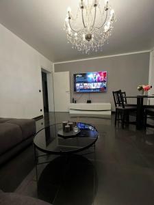 a living room with a chandelier and a glass table at Ferienwohnung Noni im Herzen von Bad Neuenahr in Bad Neuenahr-Ahrweiler