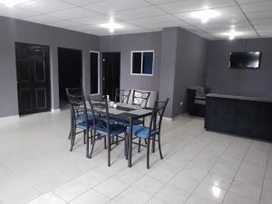 a dining room with a black table and blue chairs at Apartamento familiar 1 con 3 habitaciones y 4 camas in San Salvador +13 photos