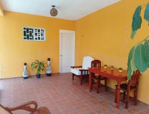 a dining room with yellow walls and a table and chairs at Apartment in Finca Mayfran in Xul-Ha