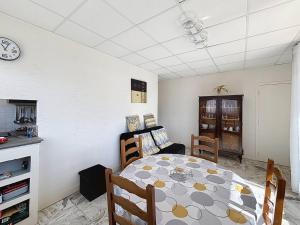 a dining room with a table and a clock on the wall at Confortable appartement proche du Port Guillaume pour 4 avec animaux admis - FR-1-465-125 in Dives-sur-Mer +6 photos
