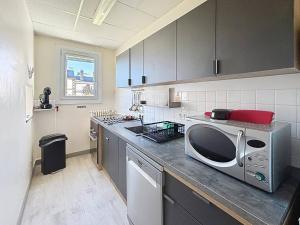 a kitchen with a microwave on top of a counter at Confortable appartement proche du Port Guillaume pour 4 avec animaux admis - FR-1-465-125 in Dives-sur-Mer