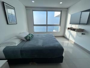 a bedroom with a large bed and a large window at Apartamento en Edificio Palmetto Beach frente a la Playa in Cartagena de Indias +3 photos