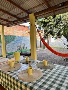 a table with yellow cups on a checkered table cloth at Casa Amarela in Presidente Figueiredo