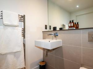 a bathroom with a white sink and a mirror at 4 Ocean Gate in Newquay +17 photos