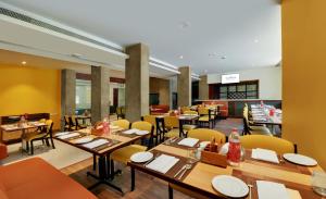 a dining room with tables and chairs in a restaurant at The Fern Residency Woodland, Pune in Pune