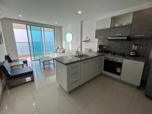 a kitchen and living room with a couch at Apartamento en Edificio Palmetto Beach frente a la Playa in Cartagena de Indias