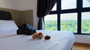 a person laying on a bed with pumpkins on it at Gamuda Cove Splash Mania Forest View Fully Air-Con Suite in Bandar Gamuda Cove