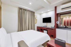 a hotel room with a bed and a television at Hotel Avenue Suwon in Suwon
