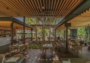 a restaurant with wooden ceilings and tables and chairs at Stay Wellbeing & Lifestyle Resort in Rawai Beach
