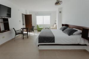 una camera da letto con un letto, un tavolo e delle sedie di Hotel Plataneras Confort a Turbo