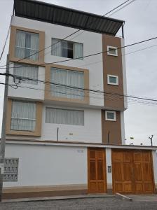 a tall building with two doors and a balcony at Apartamento San Jose Tacna 2 habitaciones in Tacna
