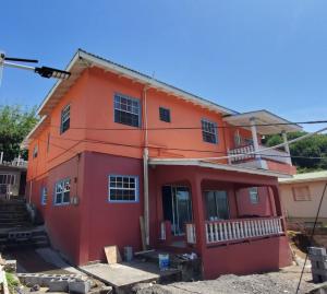una casa roja está en construcción en Michael's Beach Complex #3, en Brighton Village