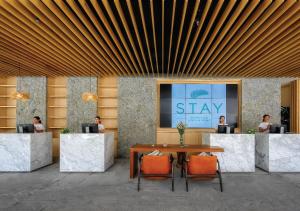 a group of people sitting at a table in a lobby at Stay Wellbeing & Lifestyle Resort in Rawai Beach