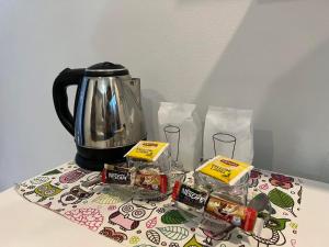 a table topped with a tea kettle and packets of food at ซีมอน เกสเฮ้าส์ in Phetchaburi