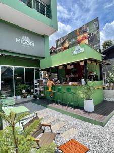 a woman standing in front of a restaurant at Midori Rawai Hotel in Ban Saiyuan (1)
