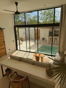 a living room with a couch and a large window at Ecstatic Villa, heart of Uluwatu in Uluwatu +18 photos