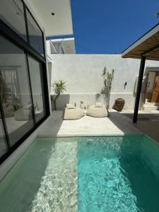 a swimming pool in front of a house at Ecstatic Villa, heart of Uluwatu in Uluwatu
