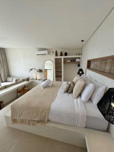 a white bedroom with a large white bed with pillows at Ecstatic Villa, heart of Uluwatu in Uluwatu