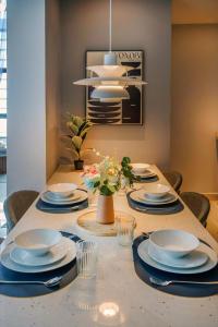 ein Esstisch mit Tellern und Schüsseln und einem Kronleuchter in der Unterkunft Novo Ampang, Luxury Premium 3BR Penthouse, Kuala Lumpur by Cobnb in Kuala Lumpur