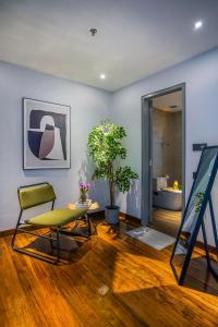 Zimmer mit einem Stuhl, einem Tisch und einem Bad in der Unterkunft Novo Ampang, Luxury Premium 3BR Penthouse, Kuala Lumpur by Cobnb in Kuala Lumpur