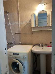 a bathroom with a washing machine and a sink at Departamento La Paz in La Falda +19 photos