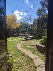 a garden with a fence and a stone path at Departamento La Paz in La Falda