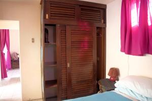 a bedroom with a wooden closet with a bed at Lakeside apartment in San Pedro La Laguna