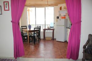 a kitchen with purple curtains and a table and a table and chairs at Lakeside apartment in San Pedro La Laguna +19 photos