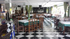 restauracja ze stołami i krzesłami oraz podłogą wyłożoną szachownicą w obiekcie Alojamiento Jose Carlos w Maladze